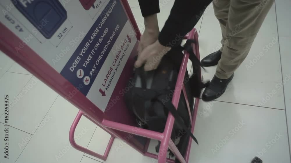 The man check the size of valise in the airport