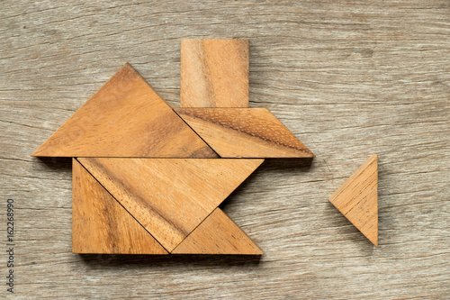 Wooden tangram puzzle in home shape wait for completion (Concept for family building or dream life)