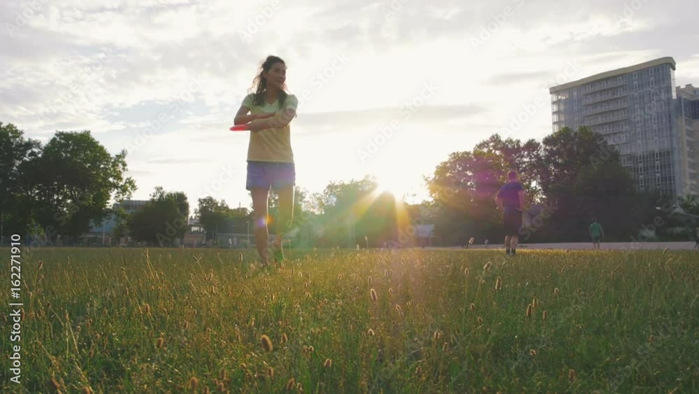 young and beautiful woman playing frisbee in the park, slow motion young and beautiful woman playing frisbee in the park, slow motion