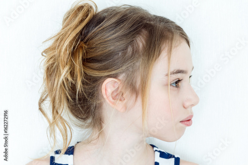 Cute girl with blond long hair in profile