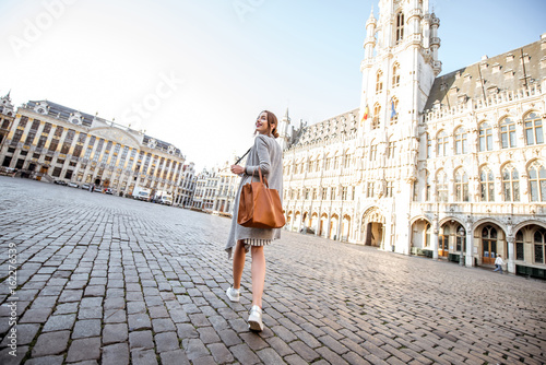 Young female tourist walking on the main square with city hall in the old town of Brussels in Belgium