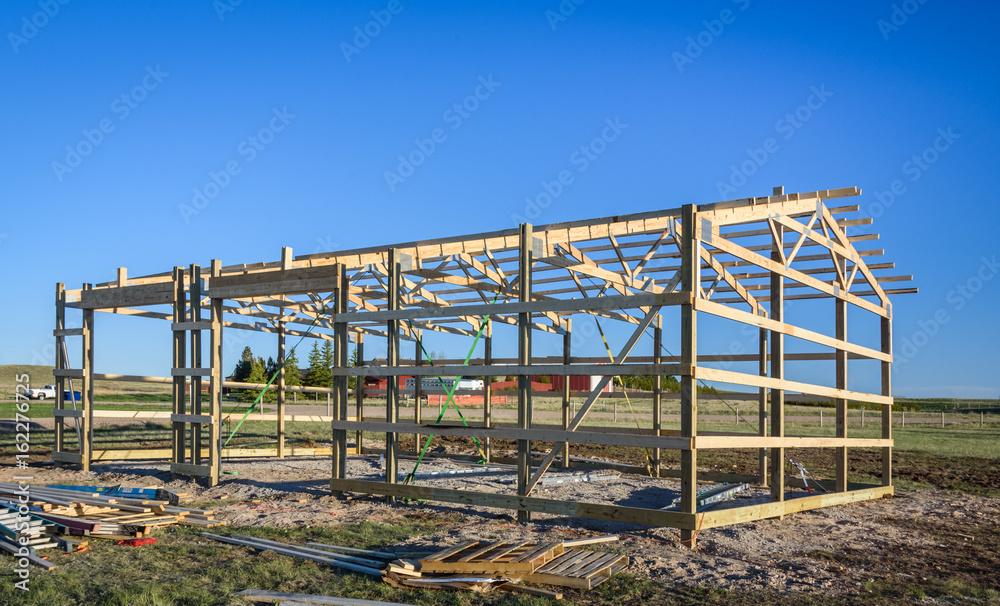 Garage construction in suburbia, USA. Wood, wooden roof truss system. Suburban building. Garage construction in suburbia, USA. Wood, wooden roof truss system. Suburban building.