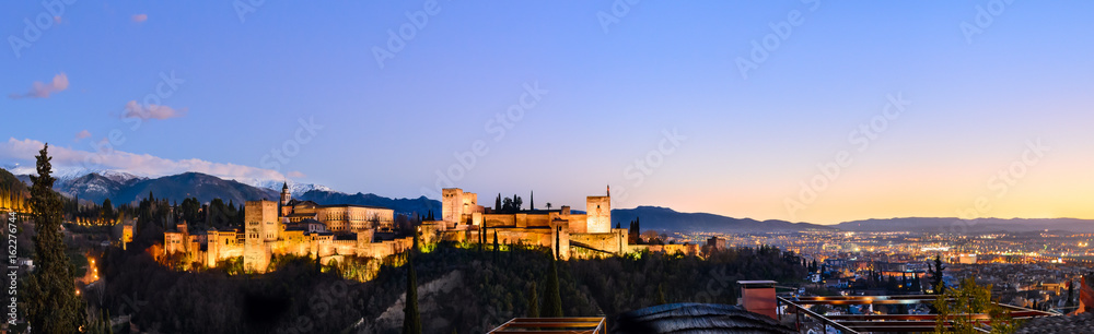 Alhambra fortress night view against Sierra Nevada mountains, Granada, Spain