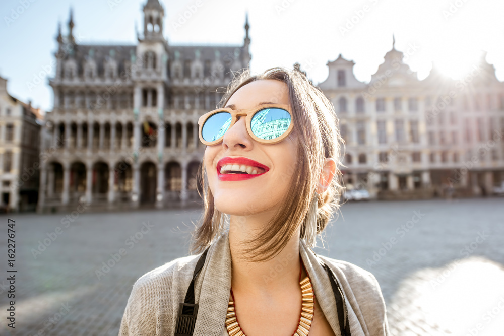 Young excited woman standing on the central square of the old town in  Brussels during the morning. City hall reflected on the sunglasses Photos |  Adobe Stock