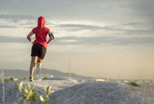 Woman running. Female runner jogging, training for marathon. Fit girl fitness athlete model exercising outdoor.