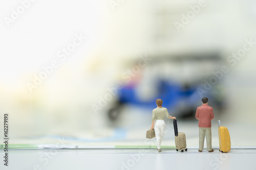 Business and Travel Concept. Businessman and woman with lagguage standing on map and looking to 3 wheels motor vehicle. photo