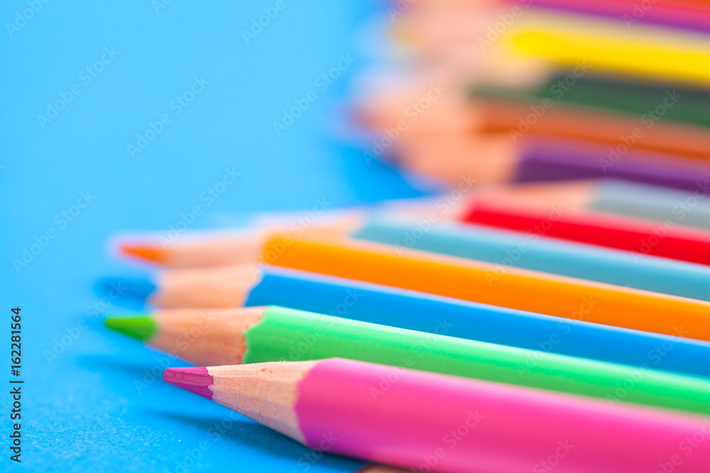 Wooden color pencils on a blue background. Prospect. The leads of colored pencils. Colored pencils closeup. Wooden color pencils on a blue background. Prospect. The leads of colored pencils. Colored pencils closeup.