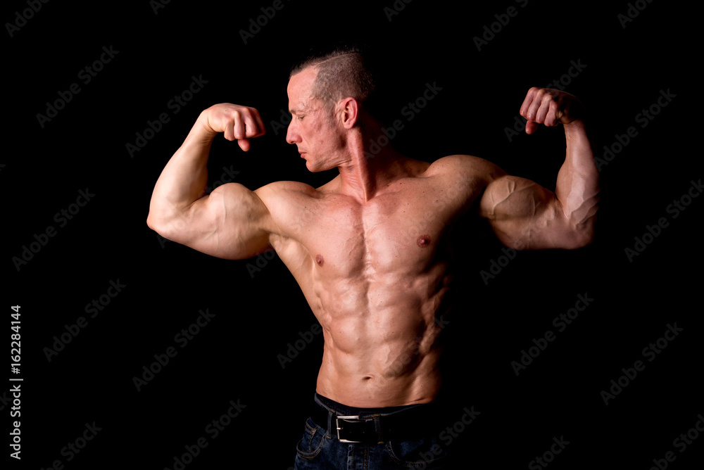 fit muscular man posing isolated on a dark background