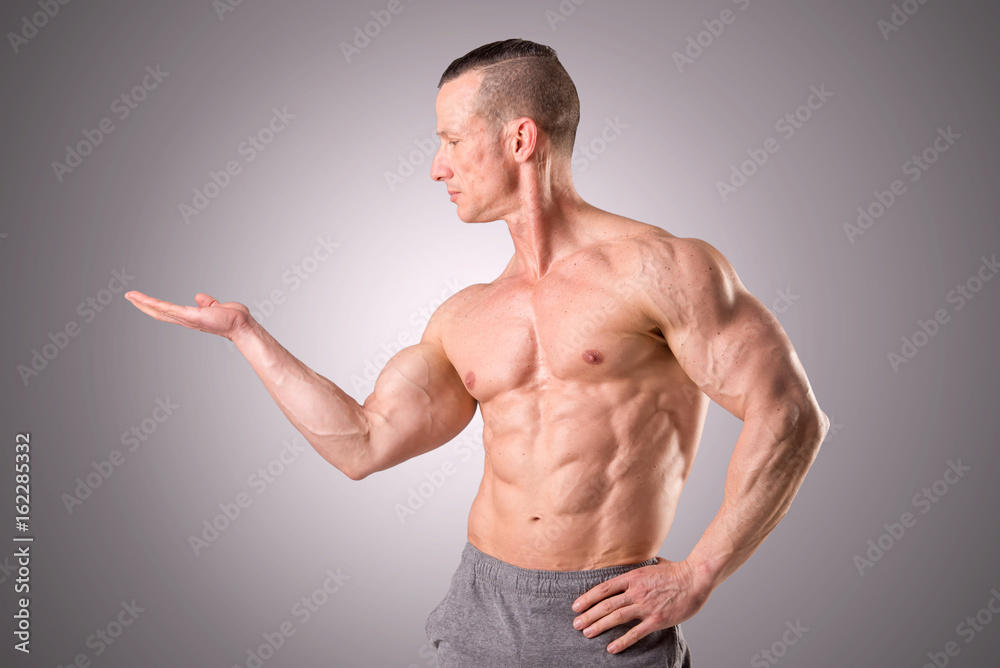 fit muscular man posing isolated on a grey background fit muscular man posing isolated on a grey background