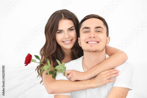 Beautiful couple with rose on light background