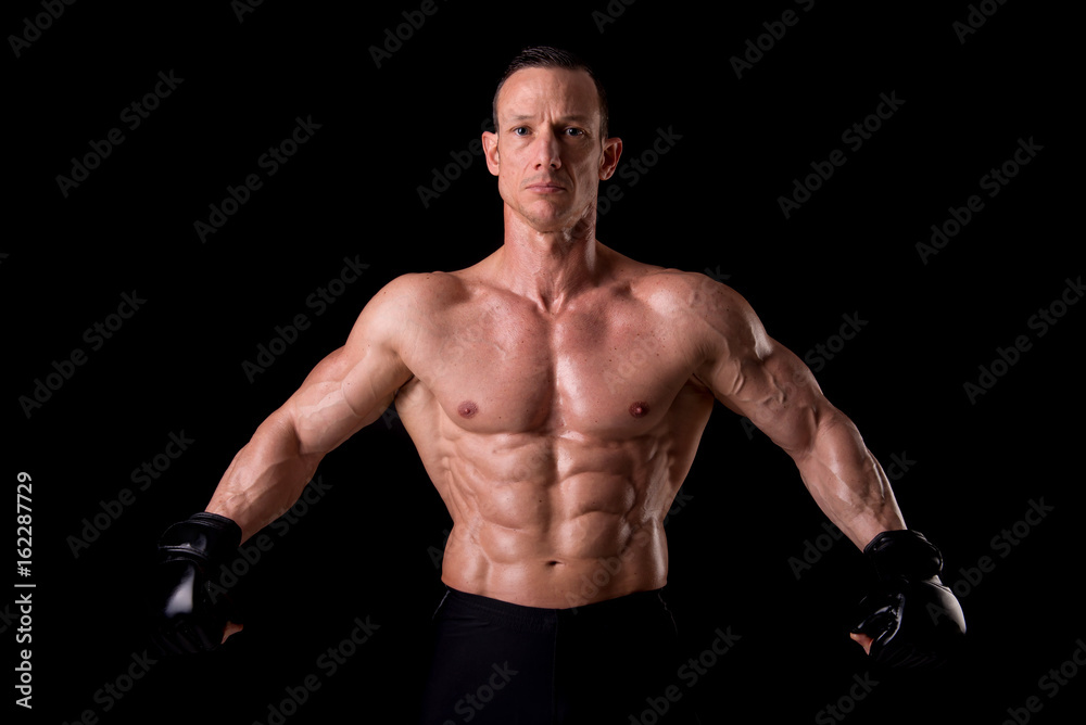 fighter posing with gloves isolated on a dark background