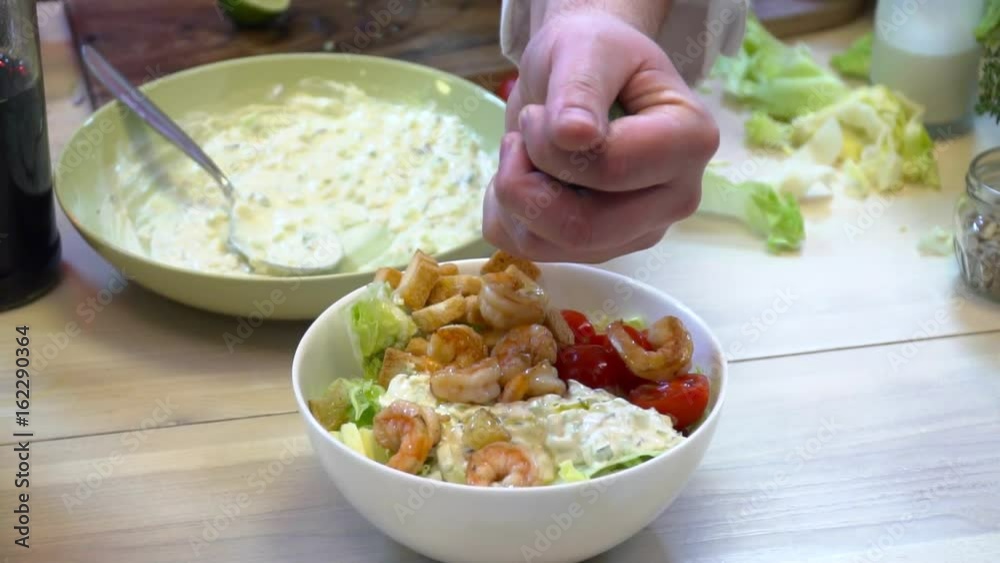 Chef adding lemon juice to the salad Chef adding lemon juice to the salad