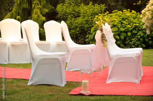 Many wedding chairs with white elegant covers photo