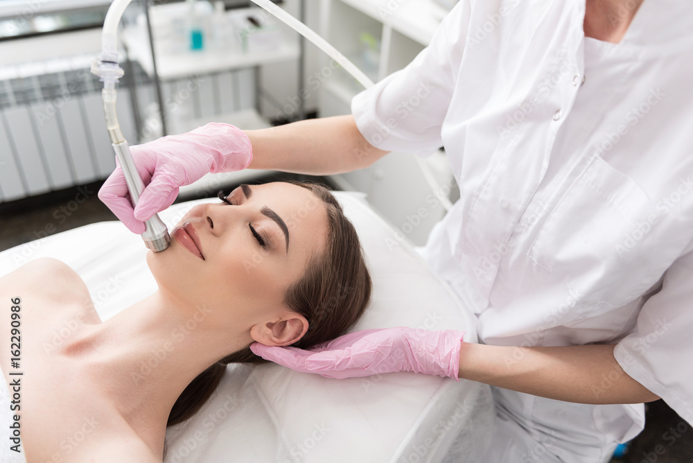 Pleasant delighted girl is lying on table in spa Pleasant delighted girl is lying on table in spa