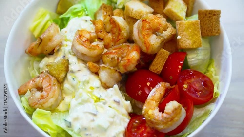 Tasty fresh slalad with shrimp on the wooden table closeup photo