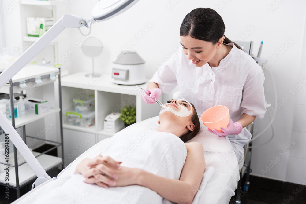 Positive beautician is working with client Positive beautician is working with client