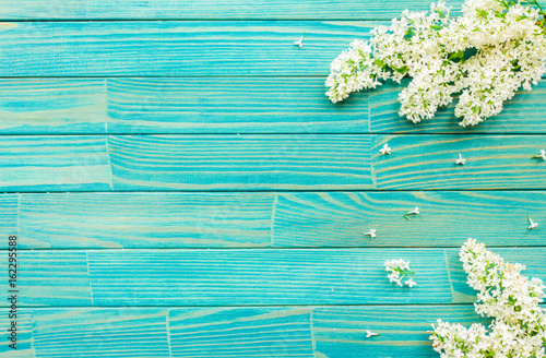 Flowers background. Lilac flowers on turquoise wooden background. Top view, flat lay, copy space