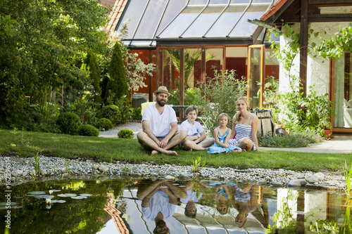 Family with two children takes a break by the pond, Munich, Bavaria, Germany