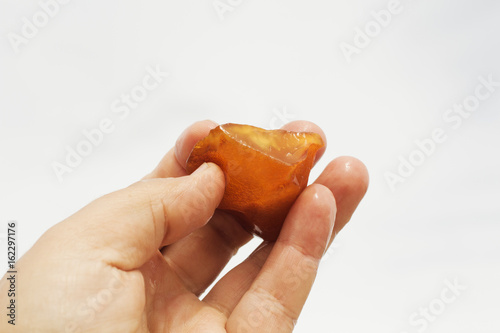 Amber in the hand with a bright reflection on the palm against the background of the sea. photo