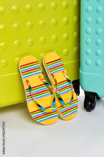 Flip tops, suitcases, white background. Meet summer adventure with bright accessories. photo