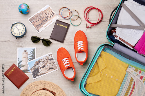 Different travelling accessories, packed suitcase. Summer holiday background. photo