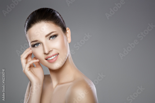 face of woman with blue eyes and clean fresh skin. Beautiful smile and white teeth