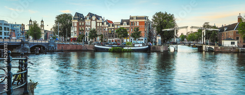 Canvas Print The most famous canals and embankments of Amsterdam city during sunset