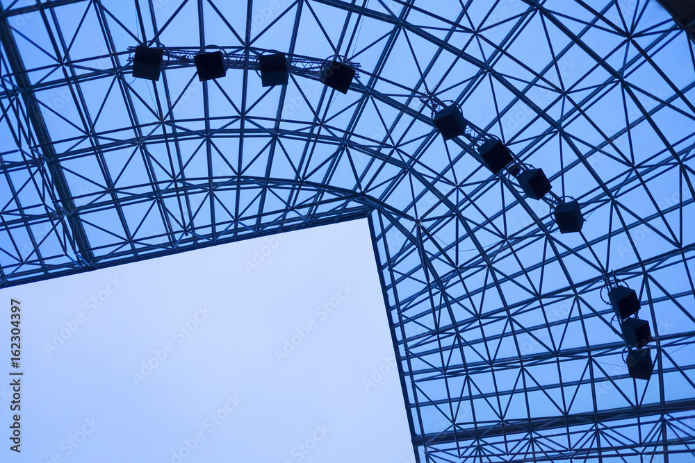 Fototapeta premium Stadium roof construction against blue sky. Modern architecture elements