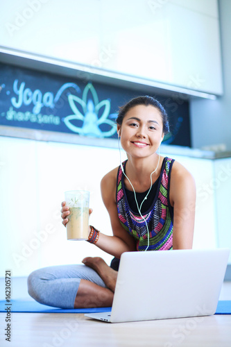 Sporty smiling woman using laptop in bright room. Woman. Lifestyle photo