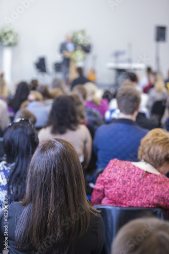 Business Concepts and Ideas. Group of Adults Listening to the Host on Stage During a Conference Indoors.