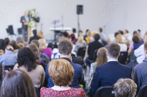 Business Concepts and Ideas. Group of Adults Listening to the Host on Stage During a Conference Indoors.