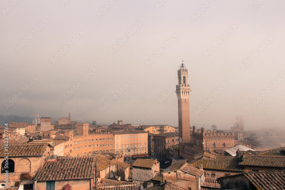 Torre del Mangia in Piazza del Campo in mist. Tuscany, Italy. Old polar effect.