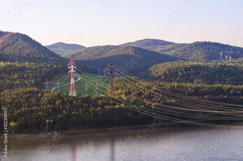 Tableau sur toile Power lines on the river bank