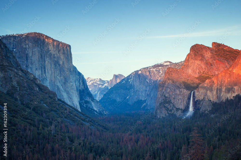 Colorful sunset in Yosemite valley, tunnel view to half dome and El capitan and tall waterfall