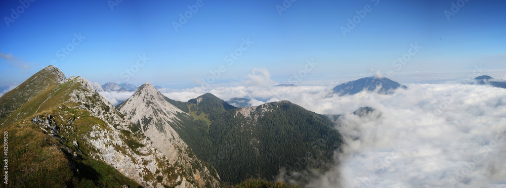 High mountain ridge hidden in clouds during sunrise, Koschuta, Slovenia