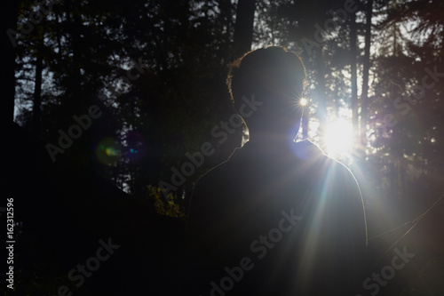 Young man in evening light silhouette in the woods