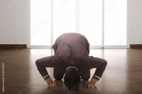 Religious asian muslim man praying to god