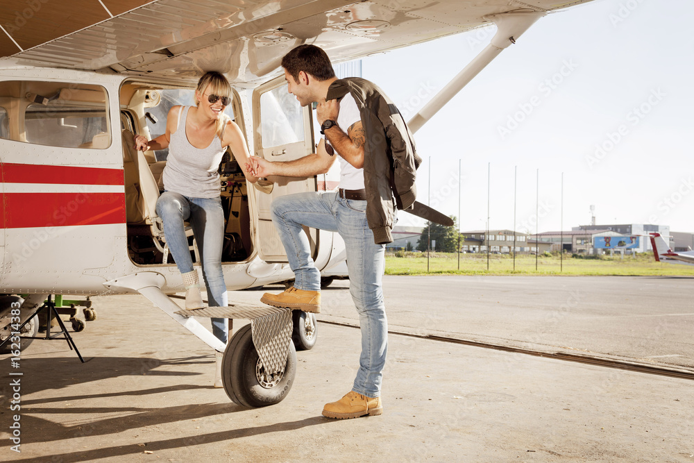 Young couple preparing for start in private airplane Young couple preparing for start in private airplane