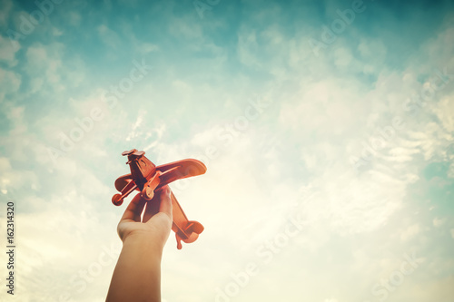 Childhood inspiration - Hands of children holding a toy plane and have dreams wants to be a pilot - Vintage filter effect