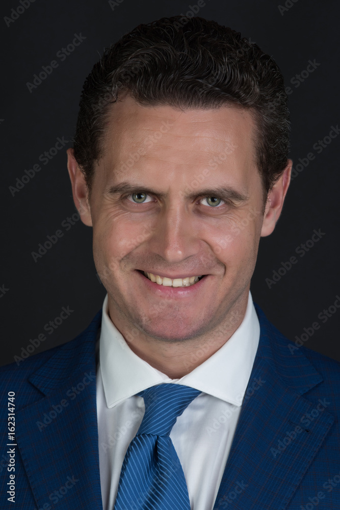 Happy man smiling in fashionable blue suit jacket and tie Happy man smiling in fashionable blue suit jacket and tie