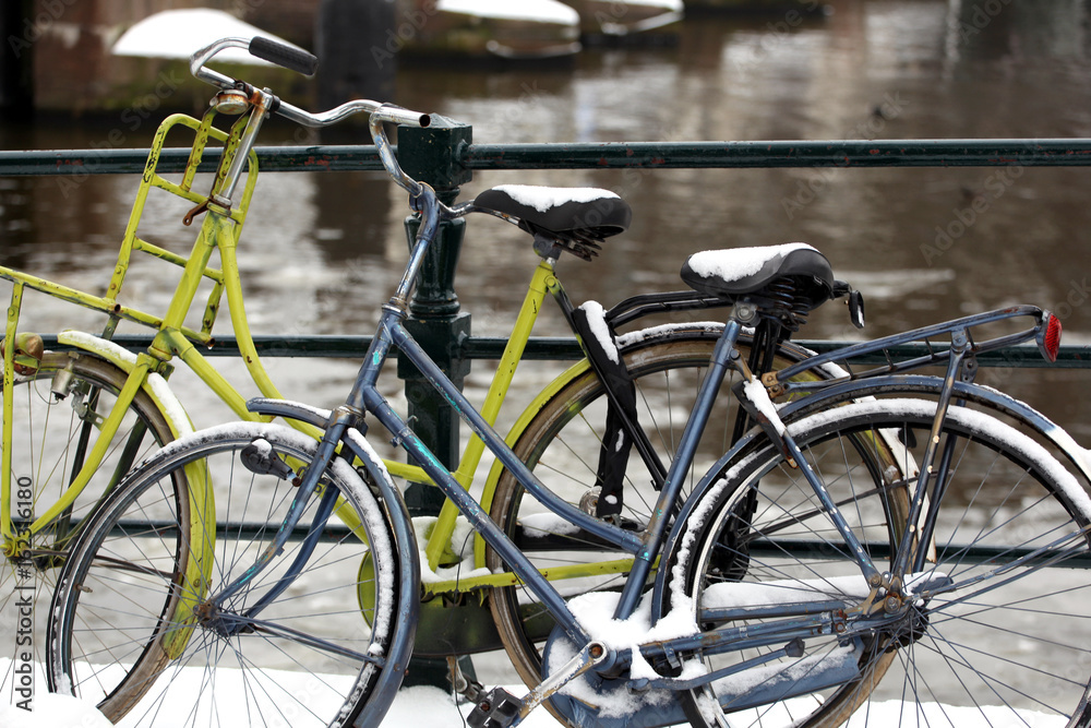Bikes parked in winter snow in Amsterdam, Netherlands.