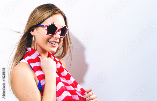 Happy young woman with USA national holiday accessories