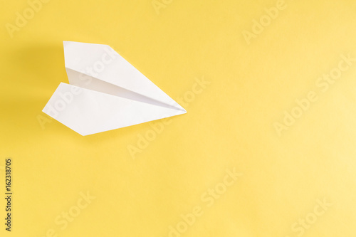 Paper airplane on a bright yellow background