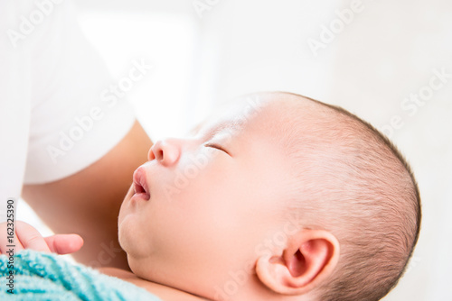 Cute little newborn baby sleeping in the arms of father