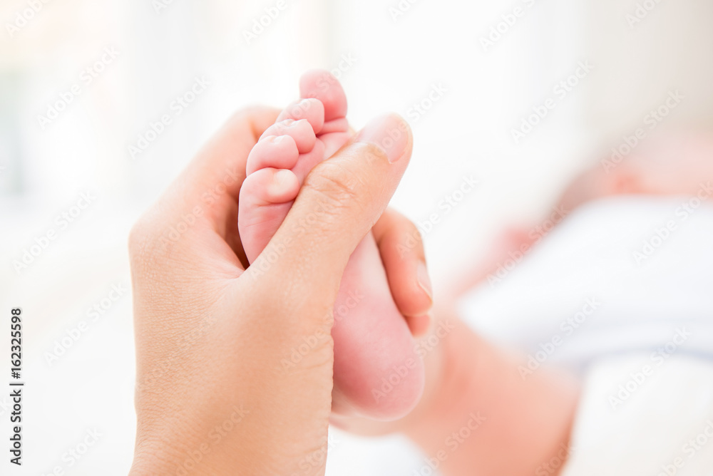 Mother hand gently touch small baby foot Mother hand gently touch small baby foot
