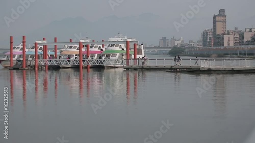 Taipei, Taiwan-06 March, 2016: People are passing by the pier to enter one of the ships docked at the Dadaocheng Wharf, located in Taipei, Taiwan photo