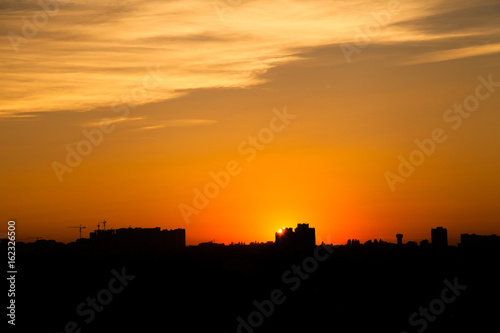 Sunset in the city beyond the horizon from the height