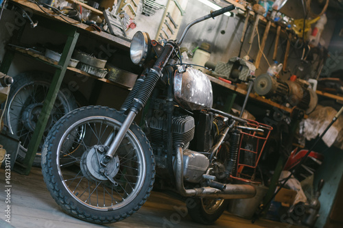 Old vintage motorcycle, which needs to be repaired, in the workshop