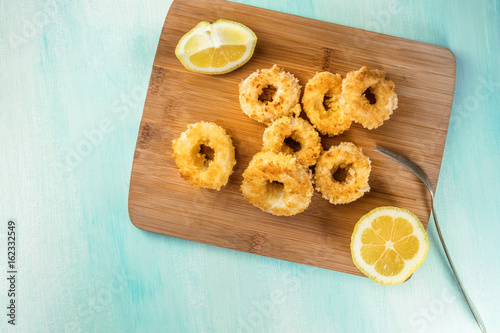 Calamari rings with lemon and copy space, overhead shot