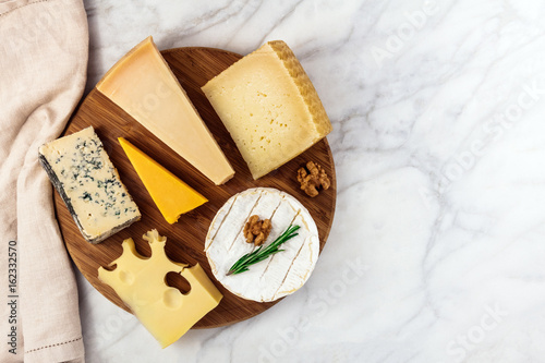Fotografía Selection of cheeses on white marble table with copyspace